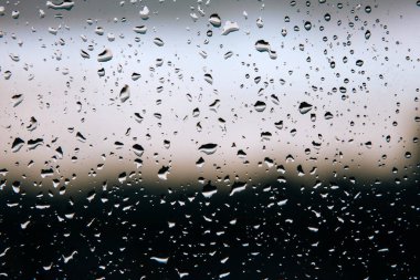 Balkondaki bardaklara yağmur üstüne su damlaları.