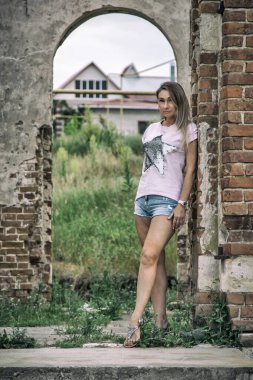 Terk edilmiş bir kilisede şortlu güzel bir kız.