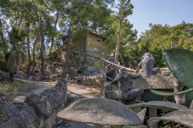 Terk edilmiş bir otelde ağaçlar ve patikalar olan bir bölge.