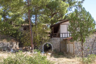 Ormandaki ağaçların arkasında terk edilmiş bir otel var.
