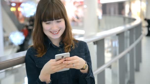 Hermosa joven empresaria con camisa y el uso de un teléfono inteligente moderno mientras camina en el descanso en la ciudad, empleadora profesional escribiendo mensaje de texto en el teléfono celular exterior, cámara lenta — Vídeo de stock