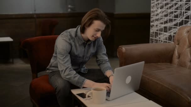 Afortunado hombre guapo trabajando en un ordenador portátil, hombre escribiendo en un ordenador portátil — Vídeo de stock