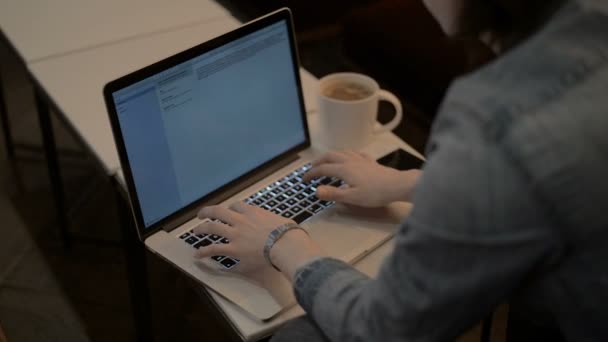 Щасливий красивий чоловік працює на ноутбуці, чоловік друкує на ноутбуці — стокове відео