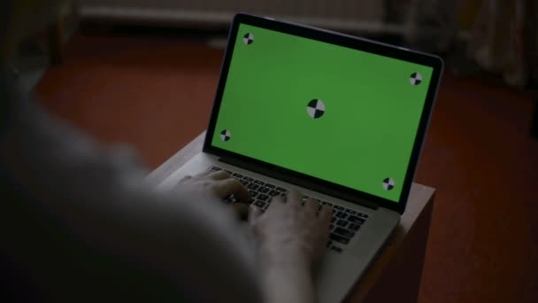a férfi típusok egy laptop asztalán. Green screen a képernyő egyéni tartalmat.