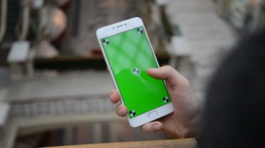 Erkek el smartphone, açık havada ve şehir merkezinde kullanarak yakın çekim. hroma anahtar. Yakın çekim. Hareket izleme. Dikey. pantolon. -