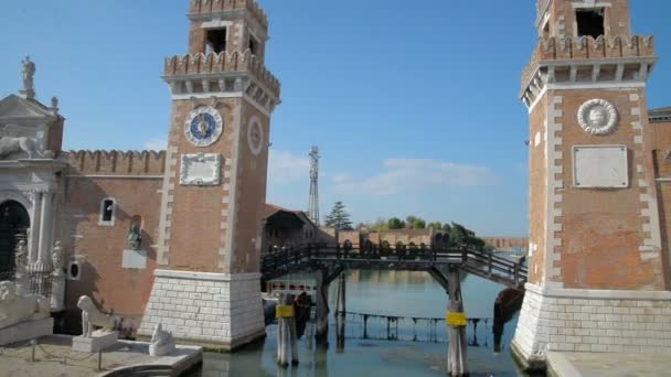 Fassaden von Reihenhäusern entlang eines venezianischen Kanals im Arsenale District Pan Eckhaus und Kanal. die porta magna des venezianischen Arsenals im Hintergrund. — Stockvideo