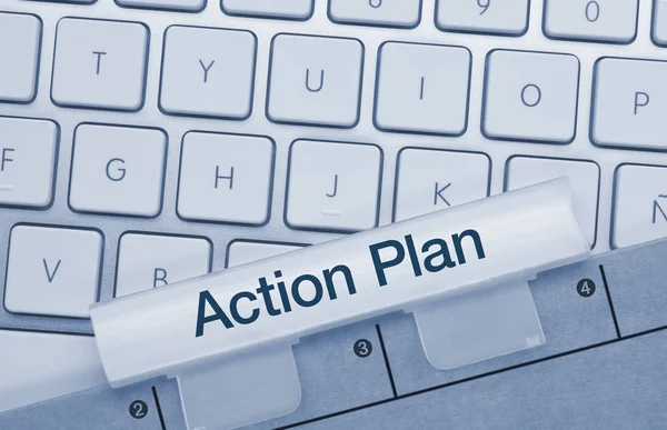 Action plan - Inscription on Blue Keyboard Key.     Action plan Written on Blue Key of Metallic Keyboard. Finger pressing key.