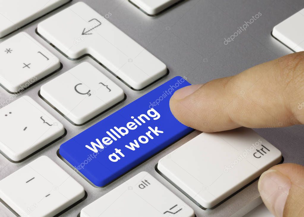 Wellbeing at work - Inscription on Blue Keyboard Key. Wellbeing at work Written on Blue Key of Metallic Keyboard. Finger pressing key.