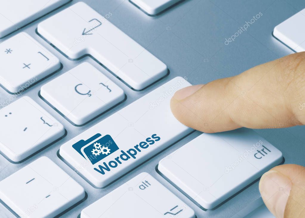 Wordpress - Inscription on White Keyboard Key. Wordpress Written on White Key of Metallic Keyboard. Finger pressing key.