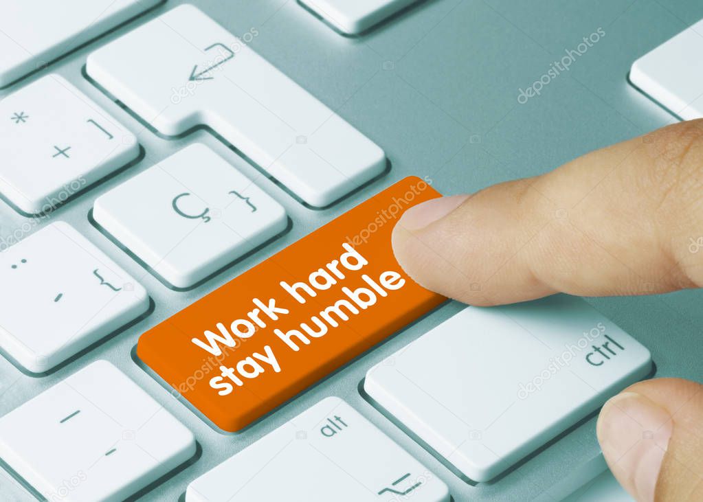 Work hard stay humble - Inscription on Orange Keyboard Key. Work hard stay humble Written on Orange Key of Metallic Keyboard. Finger pressing key.