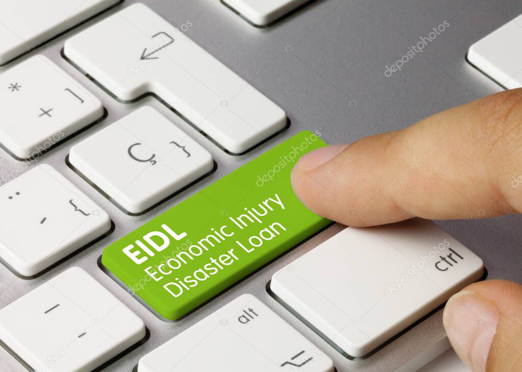 EIDL Economic Injury Disaster Loan Written on Green Key of Metallic Keyboard. Finger pressing key.