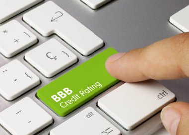 BBB Credit rating Written on Green Key of Metallic Keyboard. Finger pressing key. clipart