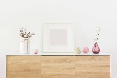 Oturma odasının iç kısmında boş kare beyaz çerçeve ve İskandinav dekorasyonu