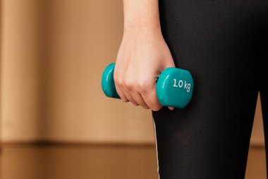 Elinde dambıl tutan genç bir kadının stok fotoğrafı.