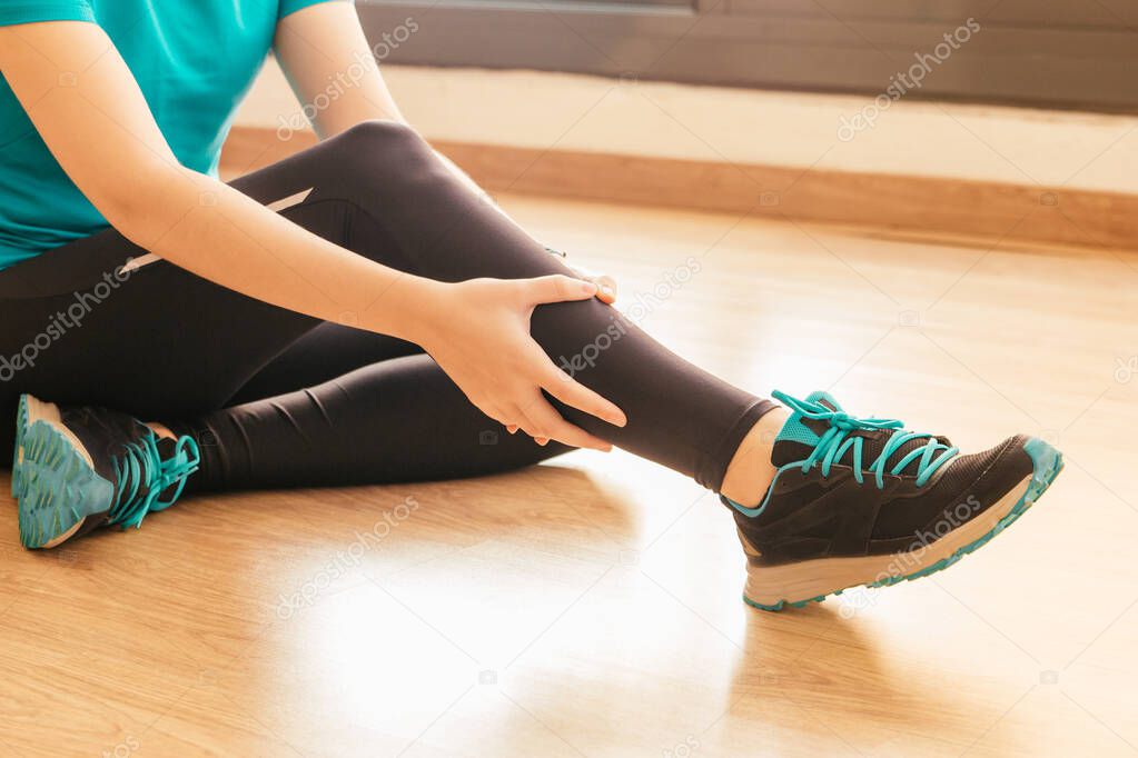 Stock photo of a young woman with a painful leg injury