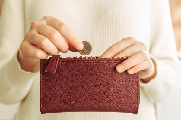 Stock photo of hands introducing a coin in a wallet