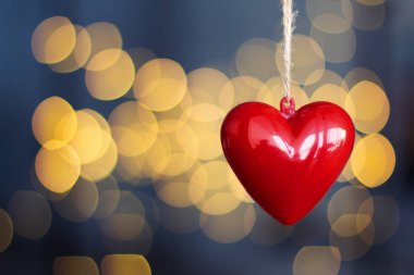 Odaklanmamış arka planda asılı kırmızı plastik kalplerin stok fotoğrafı