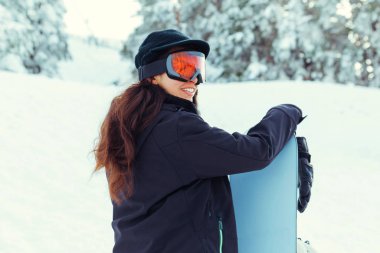 Elinde snowboard 'u olan genç bir kızın stok fotoğrafı.