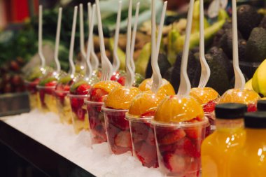 Lezzetli taze meyvelerin yenmeye hazır olduğu bir grup plastik bardağın stok fotoğrafı. Seçici odak