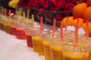 Tüketmeye hazır taze meyve sularıyla dolu bir grup plastik bardağın stok fotoğrafı. Seçici odak