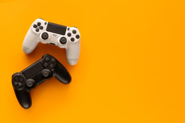 Foto Stock Dois Gamepads Fundo Amarelo Espaço Cópia Direita — Fotografia de Stock