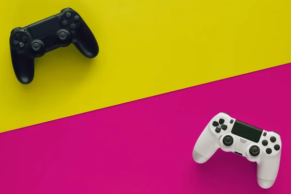 Foto Stock Dois Gamepads Dois Fundos Coloridos Espaço Cópia Meio — Fotografia de Stock