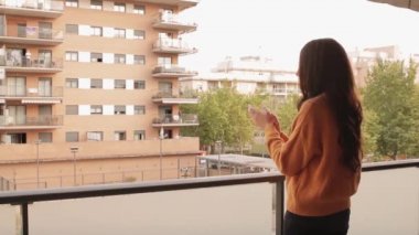 Balkonda Coronavirus 'la savaşanları alkışlayan genç bir kadının videosu.