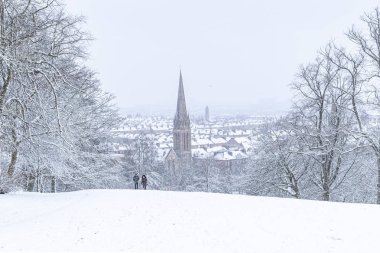 Queens Park, Southside, Glasgow, İskoçya, 2018 'deki yoğun kar yağışı sırasında parkta yürüyen bir çift.