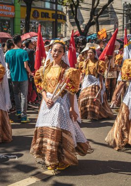 Cebu City, Filipinler - 17 Ocak 2016: Sinulog festivali sırasında geleneksel kostüm giyen genç kız sokak geçidinde yürüyor.