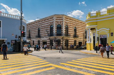Merida, Yucatan, Meksika - 05 Şubat 2017: Merida şehir merkezinde parlak boyalı koloni binalarıyla çevrili renkli zebra geçidini kullanan insanlar.