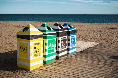 Mijas, Malaga, İspanya - 15 Aralık 2019: İspanya 'nın Malaga kıyısındaki Cala de Mijas plajında renkli çöp bidonları sırası.