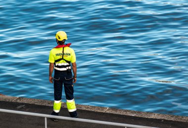 Santa Cruz de Tenerife, İspanya - 23 Aralık 2019: Bir Fred Olsen feribot hattı çalışanı üniforma giyip Santa Cruz de Tenerife limanındaki iskeleye yanaşmayı bekliyor.