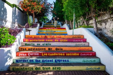 Puerto de la Cruz, Tenerife, İspanya - 18 Aralık 2019: Yaşlı turist çifti Agatha Christies ile renkli merdivenleri tırmanıyor..