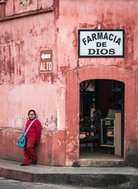 San Cristobal de las Casas, Chiapas, Meksika - 23 Mart 2017: Küçük kız yerel bir eczanenin duvarına yaslanıyor. İspanyolcada 