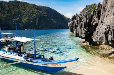 El Nido, Palawan, Filipinler - 11 Ocak 2016: Palawan adası açıklarında Sulu Denizi 'nin turkuaz sularında sakin bir körfeze demirlemiş turistik tekne.