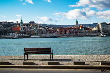 Budapest, Hungary - January 06, 2018: An empty bench overlooking the Danube river on a sunny winter day.