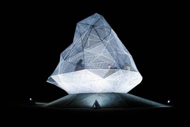 Naoshima, Japan - October 24, 2018: Sou Fujimoto's naoshima geometric pavilion illuminated by night with two silhouettes inside.