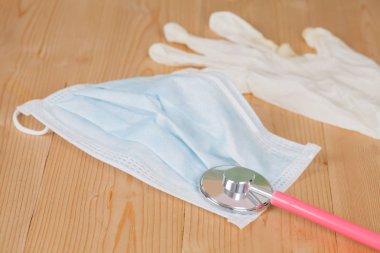 Steteskop ve ahşap arka plan üzerinde koruyucu maske, 