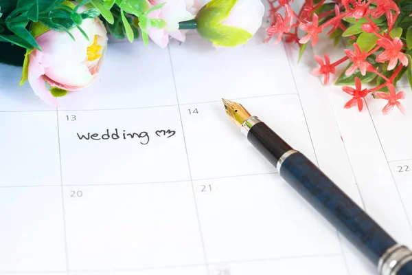 Palabra boda en el calendario con flores dulces y pluma, cono de amor —  Fotos de Stock