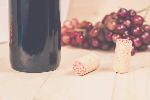 Grapes, and wine bottle on wood background — Stock Photo, Image