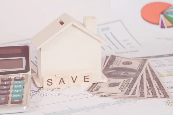 Casa em miniatura com dinheiro e gráfico — Fotografia de Stock