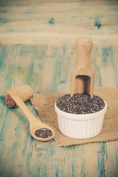 Gesunde Chiasamen in einem Holzlöffel und einer Tasse auf dem Tisch — Stockfoto