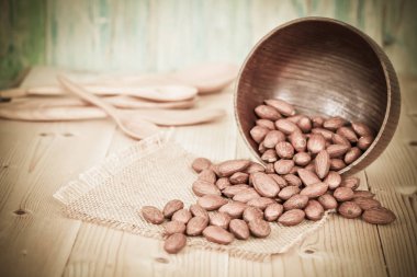 Badem desenli ahşap arka plan üzerinde kahverengi kase