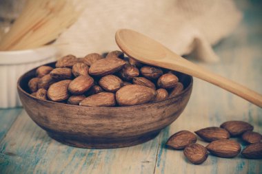 Badem desenli ahşap arka plan üzerinde kahverengi kase