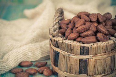 Badem desenli ahşap arka plan üzerinde kahverengi kase