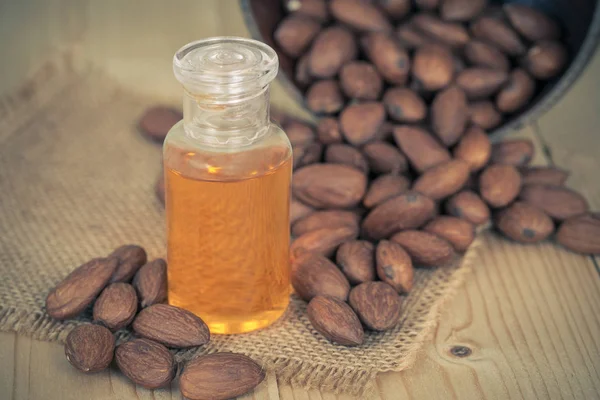 almond oil and  almonds seed on wooden background