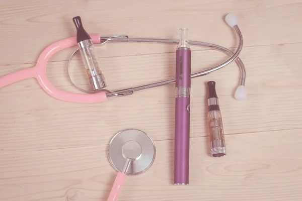 Stethoscope and e- cigarette on wood table — Stock Photo, Image