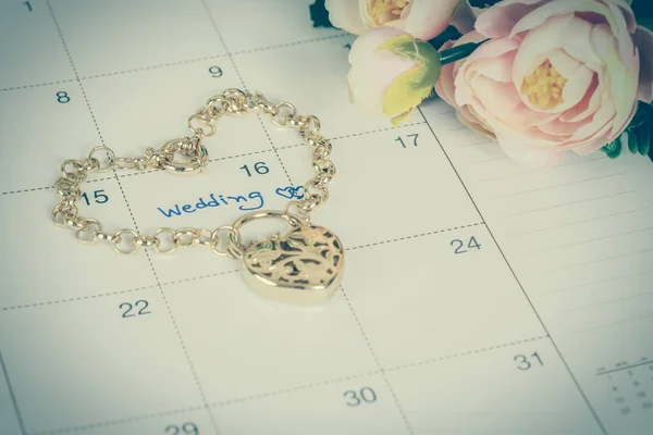 Parola matrimonio sul calendario e bracciale in oro con cuore — Foto Stock