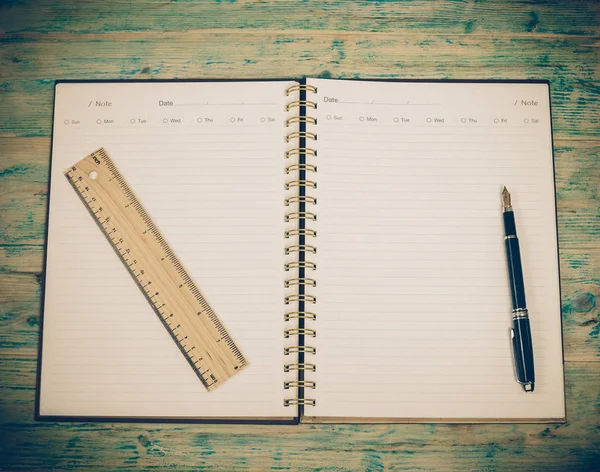 Cuaderno blanco en blanco y pluma sobre mesa de madera — Foto de Stock