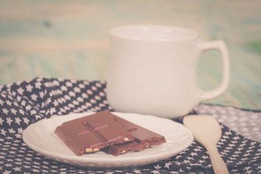 Masa örtüsü ile beyaz disk üzerinde çikolata bar